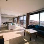 Bright and airy contemporary living room with furniture and large windows overlooking a city view.